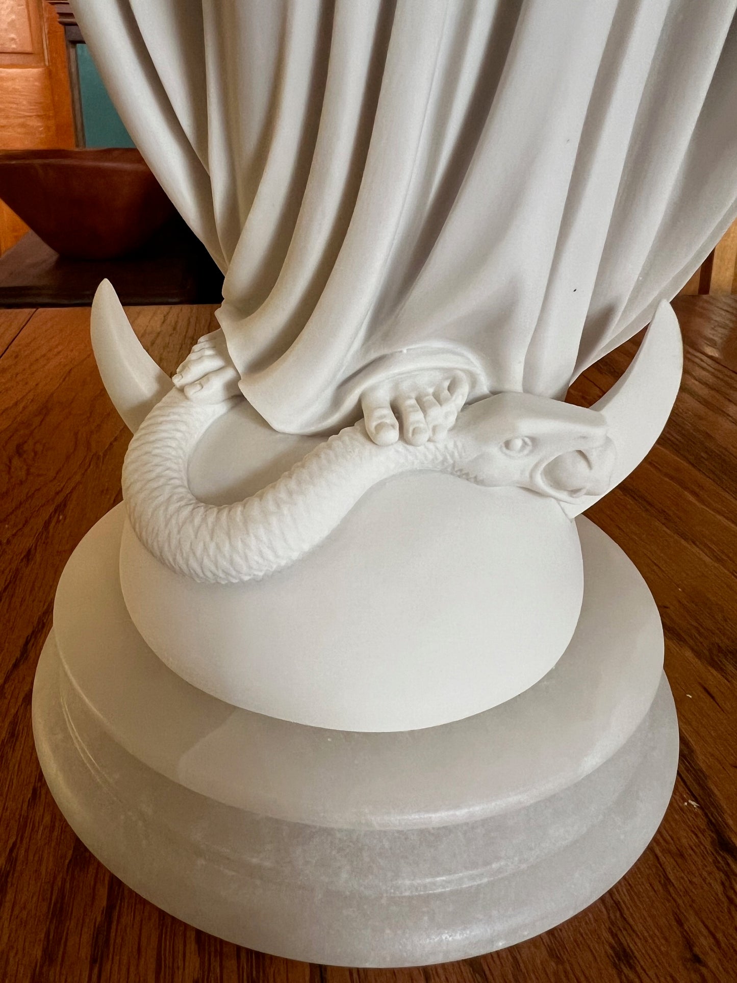 Close up of snake Virgin Mary Miraculous Medal statue crushing the serpent alabaster base