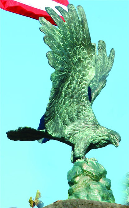 Patriotic bronze eagle statue displayed near American flag