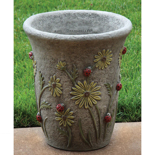 Decorative flower pot with floral and ladybug designs on a grass background