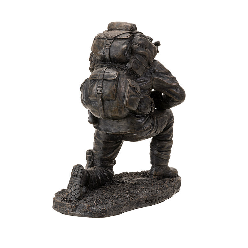 Bronze statue of a soldier with backpack on a white background