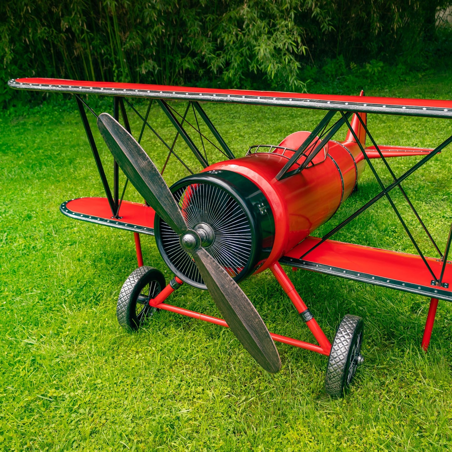 Large 10-foot red metal biplane decorative sculpture with seat and LED lighting outdoor displayed on grass