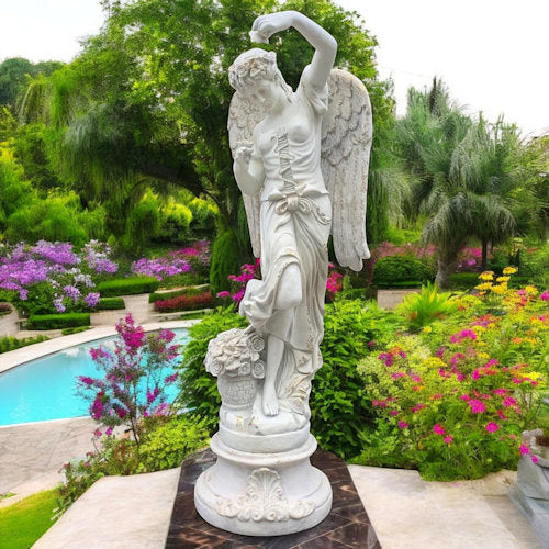 Statue of an angel in a garden with flowers and a pool in the background