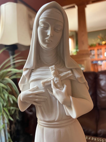 Close up of face Saint Rita religious sculpture with folded hands made of alabaster composite