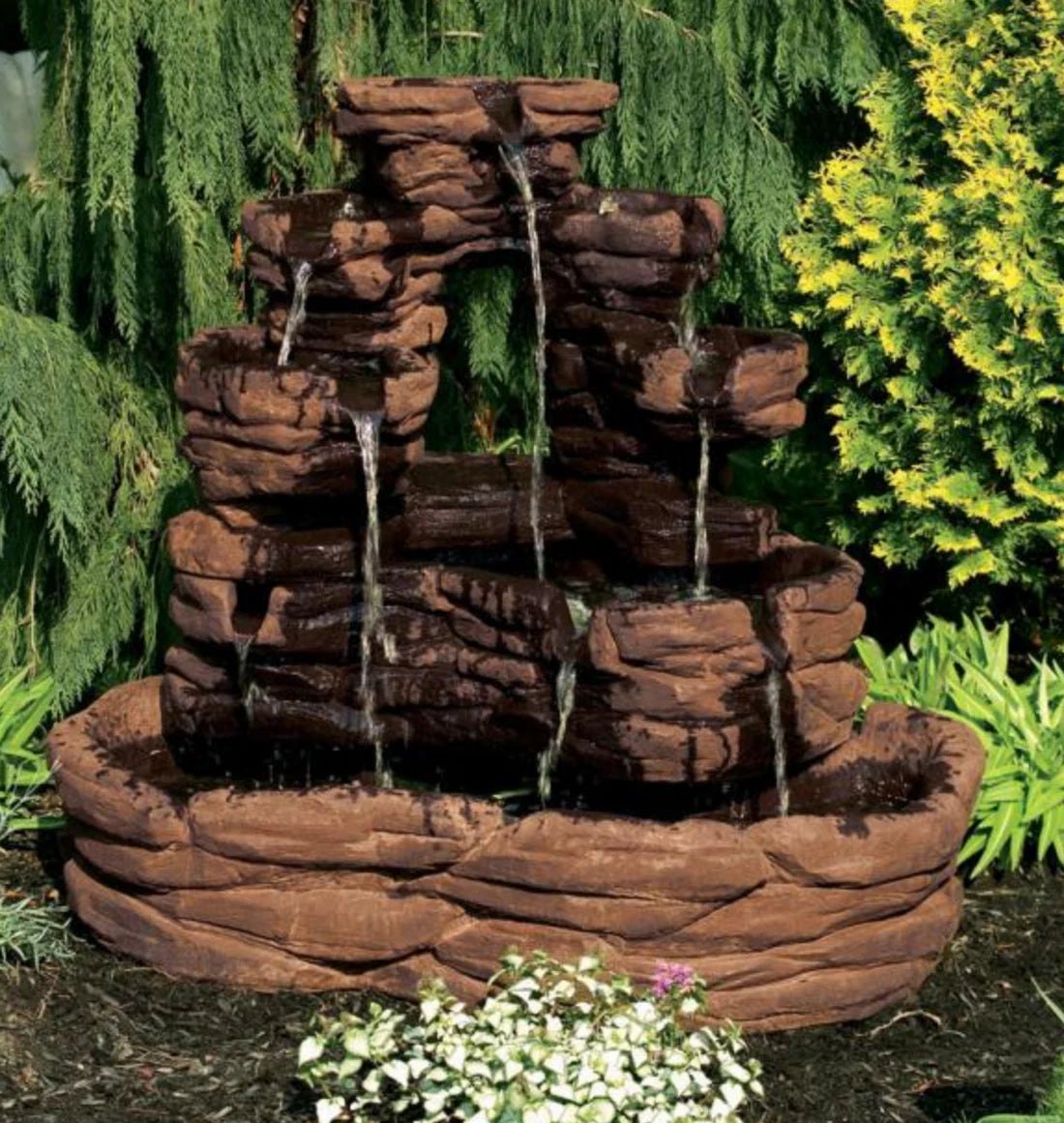 Outdoor stone water fountain with multiple tiers in a garden setting