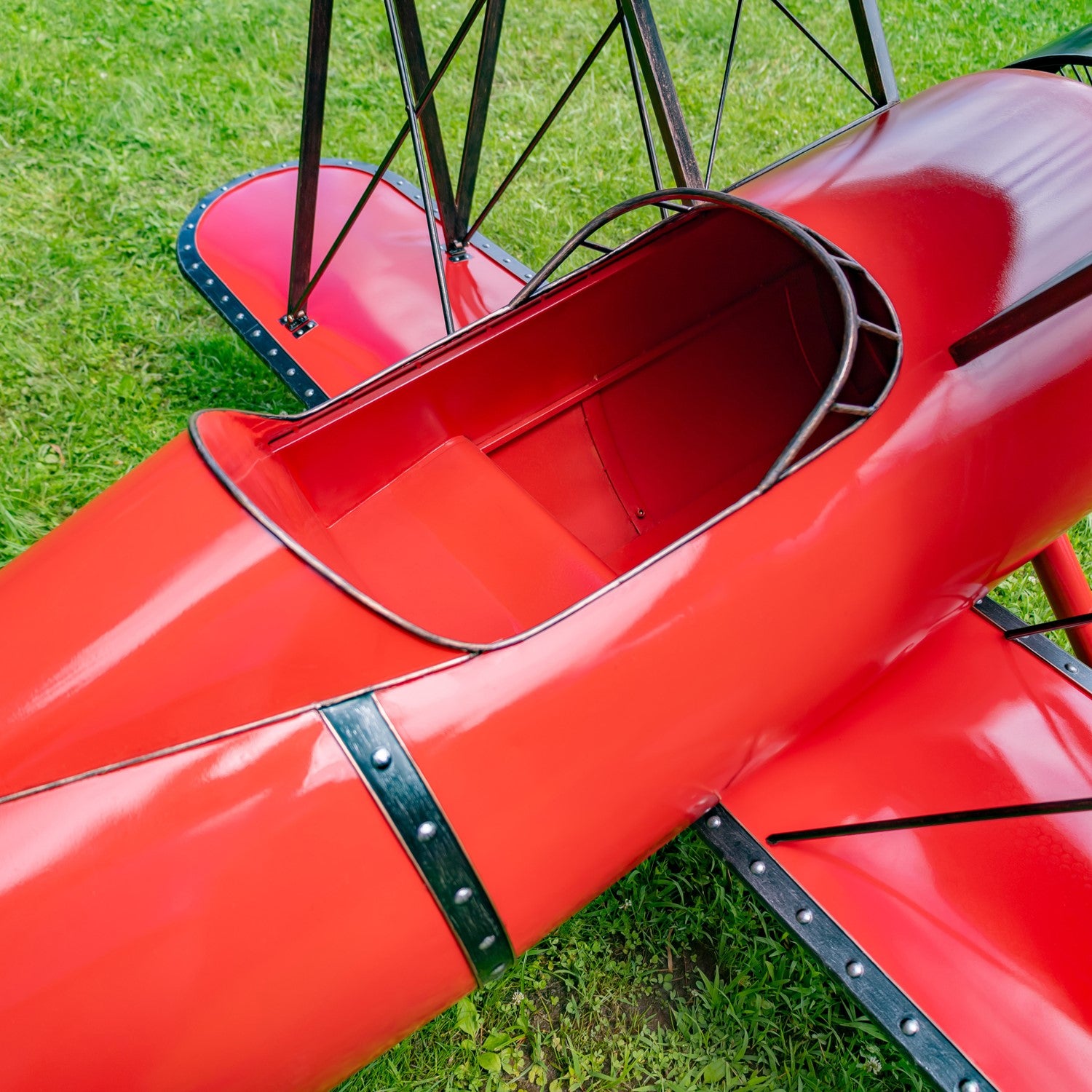 Close up of tail of airplane seating biplane sculpture outdoor display in red