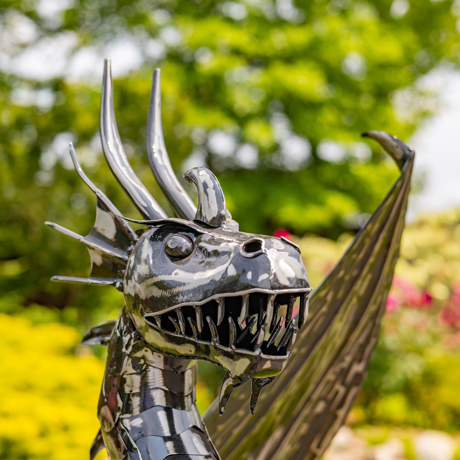 Close up of head metal dragon sculpture with a blurred natural background 