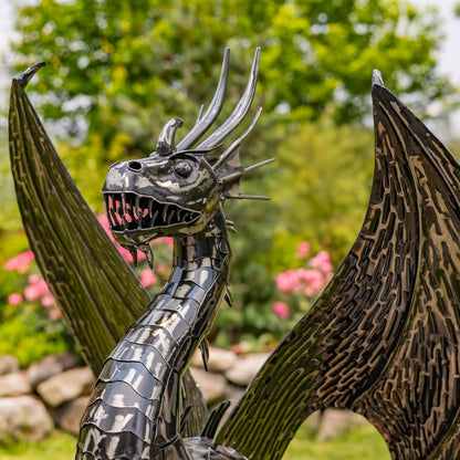 Metallic dragon sculpture with detailed features in a garden setting