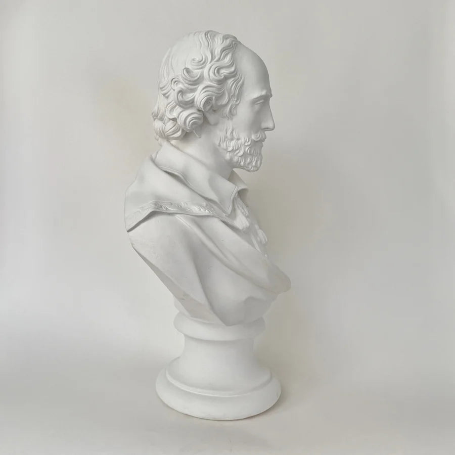 A white classical-style William Shakespeare bust sculpture of a bearded man in profile, mounted on a round pedestal