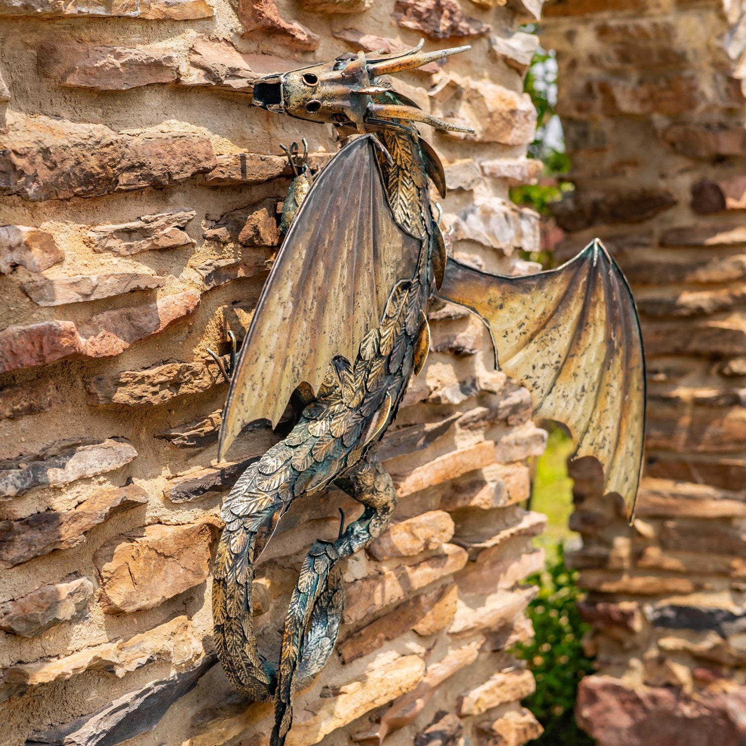 Side view Guardian Serpent wall dragon sculpture with coiled body and spread wings mounted on stone wall