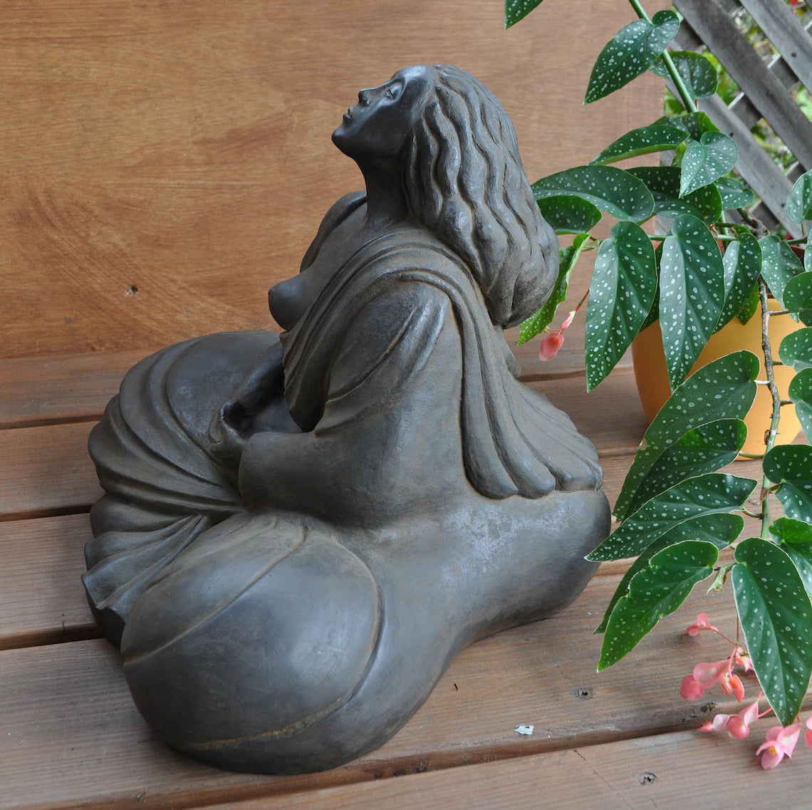 Woman Buddha sculpture sits in meditation, her breath helping her reach a still mind