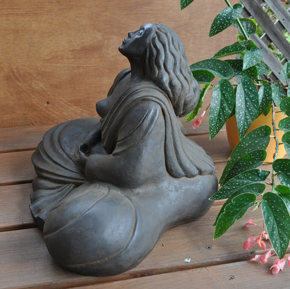 Woman Buddha sculpture sits in meditation, her breath helping her reach a still mind