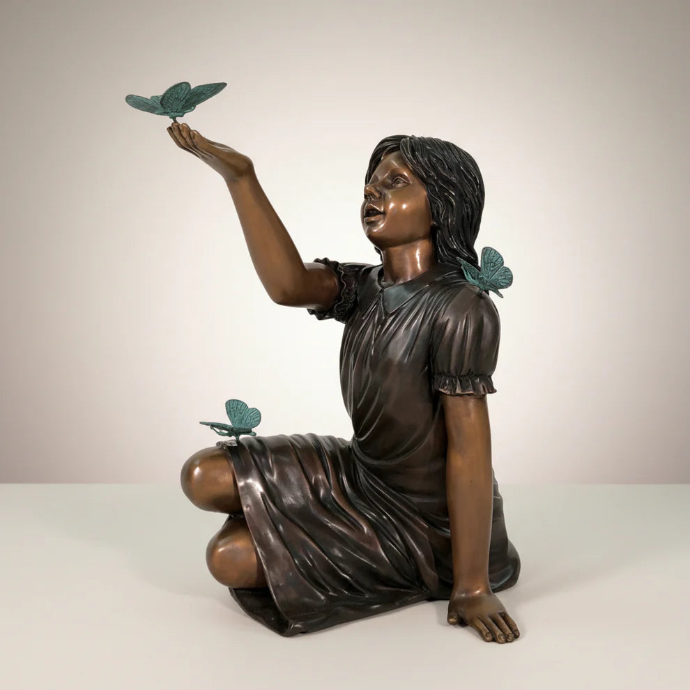 Bronze statue of a girl with butterflies on a plain background