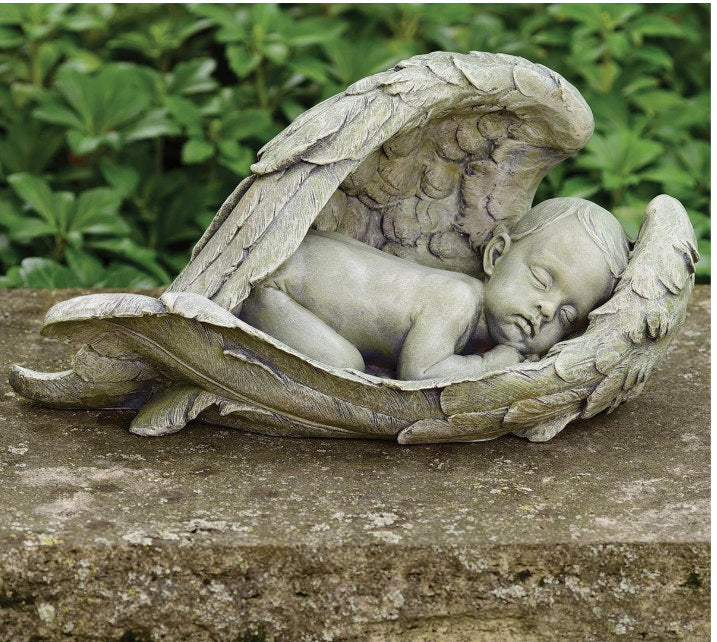 Sleeping baby nestled safely between detailed angel wings garden statue memorial
