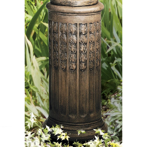 Decorative outdoor column with intricate design in a garden setting