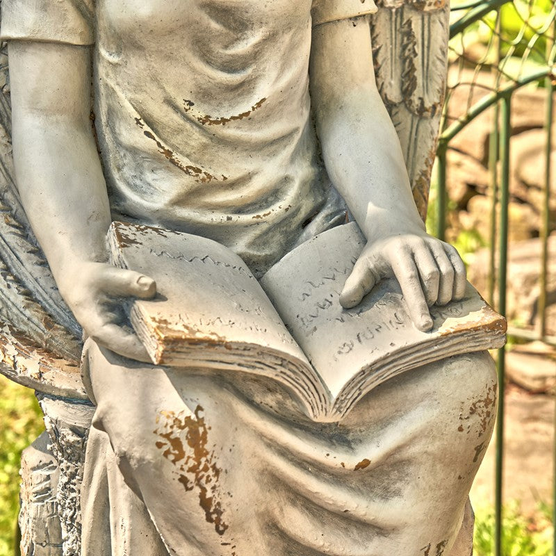Close up of book Tall Sitting Angel Statue Reading Book captures a moment of celestial reflection and timeless grace