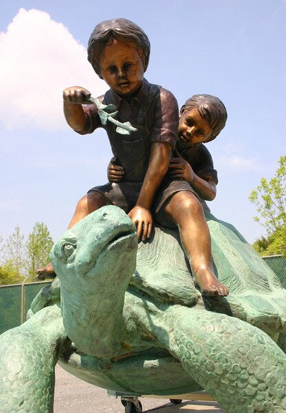 Two Boys Riding Turtle Bronze Statue feeding on top