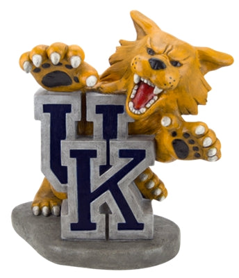 A resin figurine of an orange wildcat mascot biting down on a gray block with a navy blue 'UK' logo, set against a plain white background.