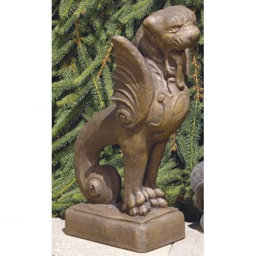 Winged Griffin  statue in front of green foliage outdoor garden sculpture