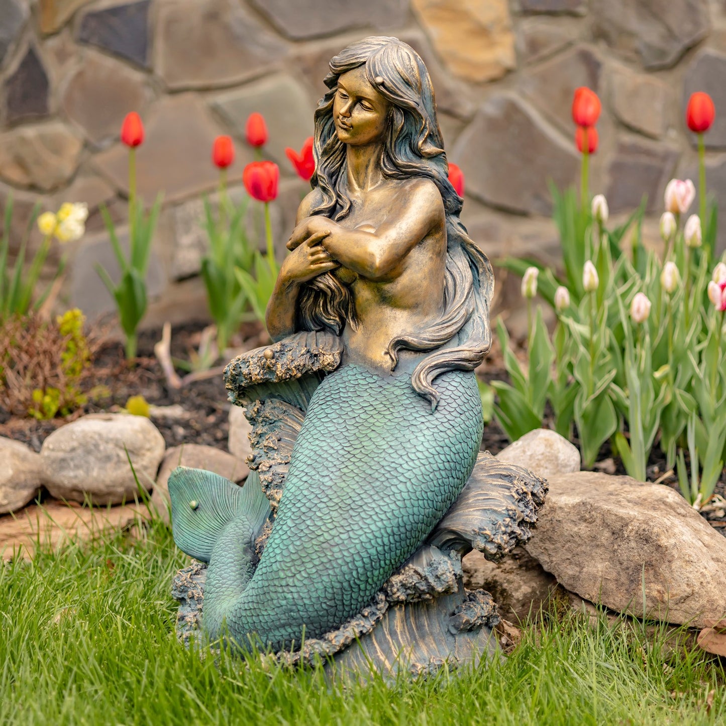 Right side view of antique bronze mermaid sculpture with detailed scales and coastal rock base