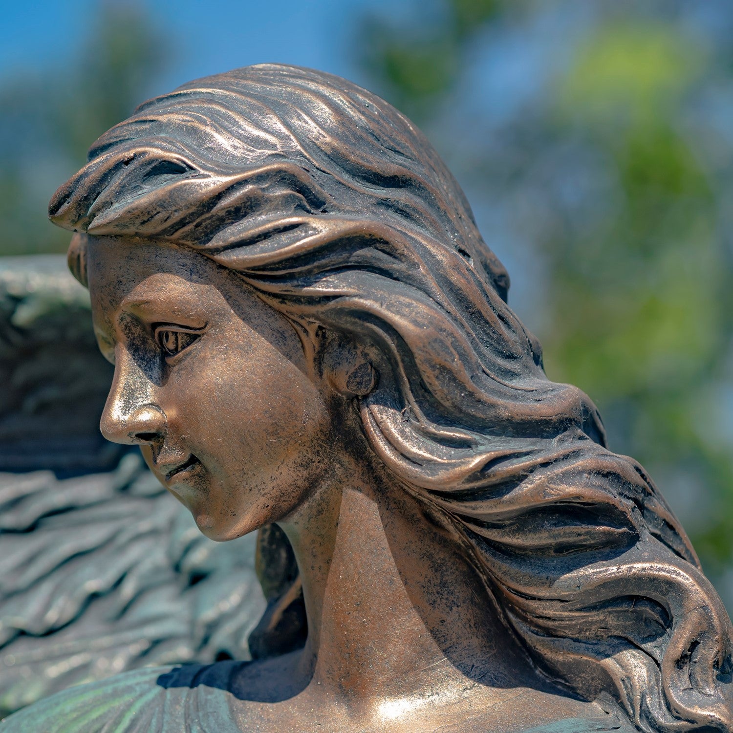 large bronze angel statue outdoor spiritual garden art close up of face and hair